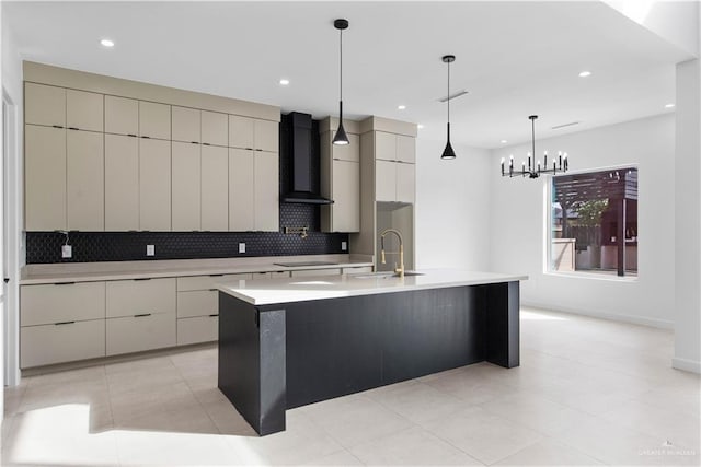 kitchen with a spacious island, sink, hanging light fixtures, wall chimney range hood, and backsplash