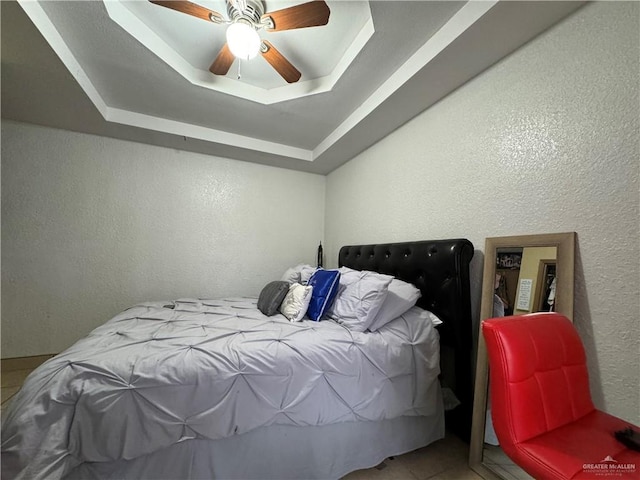 bedroom featuring a tray ceiling and ceiling fan