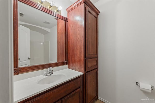 bathroom featuring a shower and vanity