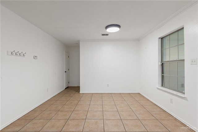 tiled spare room featuring ornamental molding