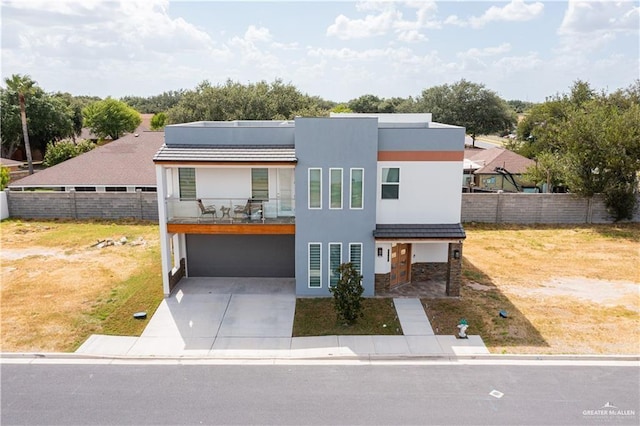 6907 N 11th Ln, Mcallen, TX 78504 - contemporary house featuring a balcony, a garage, concrete driveway, solar panels, and stone siding