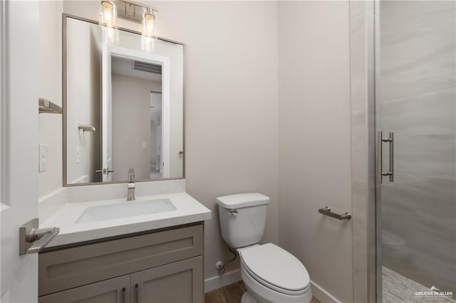 bathroom featuring an enclosed shower, vanity, and toilet