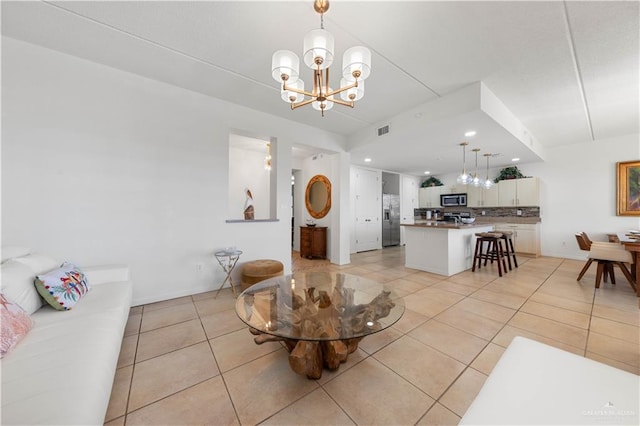 tiled living room featuring an inviting chandelier