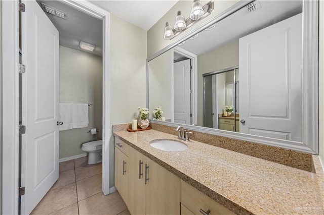 bathroom with tile patterned flooring, vanity, and toilet