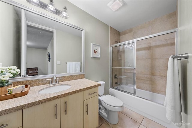 full bathroom featuring shower / bath combination with glass door, vanity, tile patterned floors, and toilet