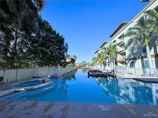 view of swimming pool with a community hot tub and a water view