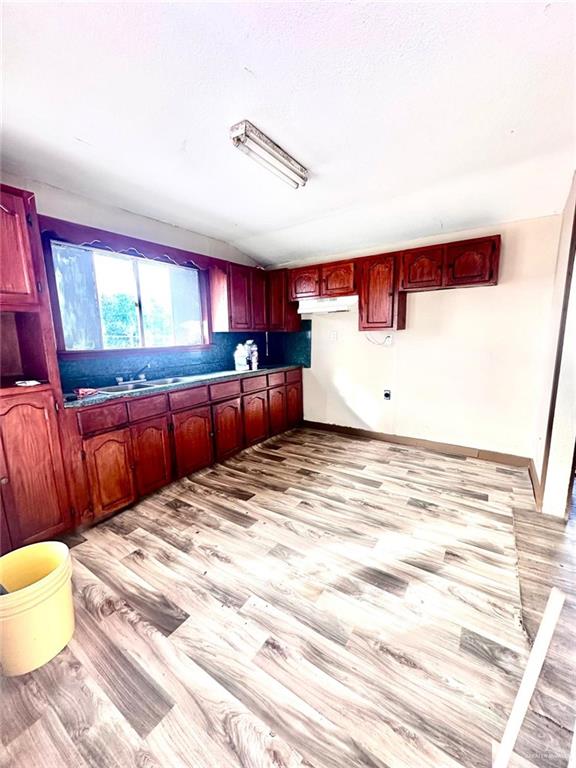 1210 SE Wright Ave SE, Pharr, TX 78577 - kitchen with light wood-style floors and dark brown cabinets