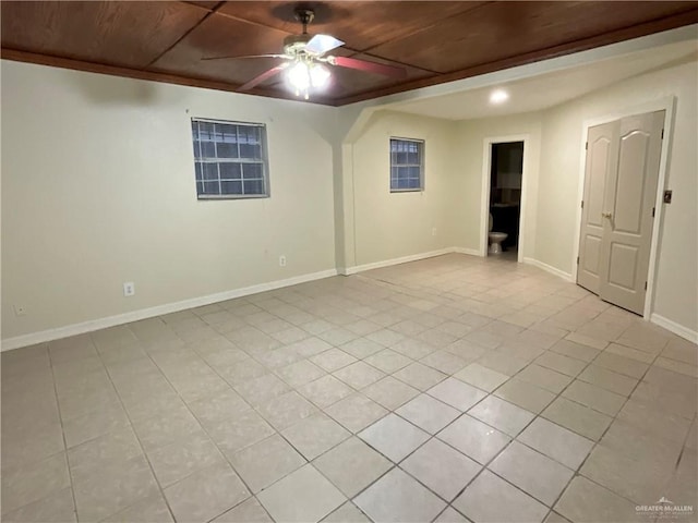 spare room featuring ceiling fan, light tile patterned floors, wooden ceiling, and baseboards