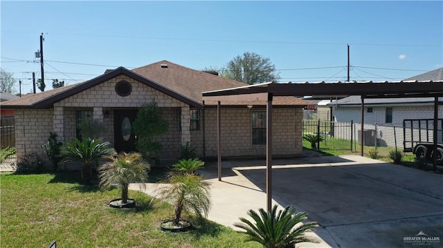 view of front facade featuring an attached carport, a front yard, and fence