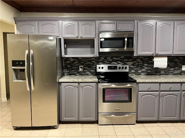 kitchen featuring light tile patterned floors, appliances with stainless steel finishes, gray cabinets, and backsplash