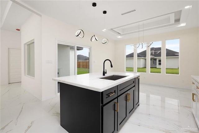 2809 E Tamarindo Ave, Hidalgo, TX 78557 - kitchen with dark cabinets, a tray ceiling, light marble finish flooring, and light countertops