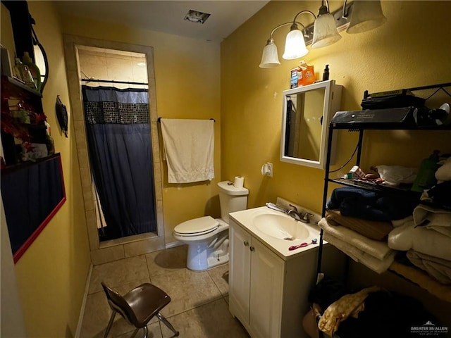 bathroom featuring tile patterned flooring, vanity, toilet, and walk in shower