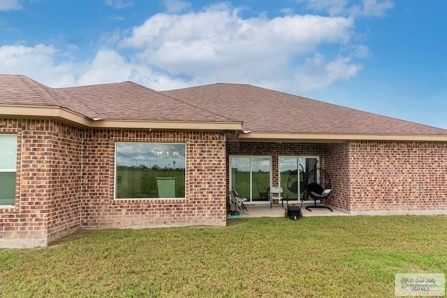 9753 Lake Arthur Ct, Los Fresnos, TX 78566 - rear view of property featuring brick siding, a lawn, roof with shingles, and a patio