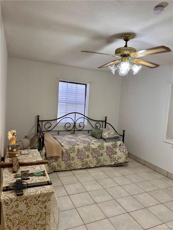 3813 N Taylor Rd, Mission, TX 78573 - bedroom with ceiling fan and light tile patterned floors