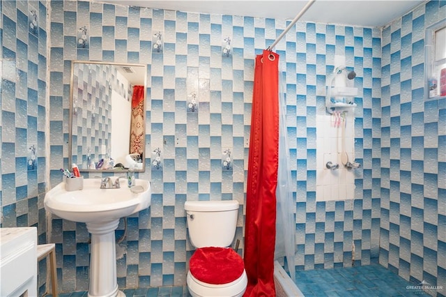 bathroom with toilet, sink, and a shower with shower curtain