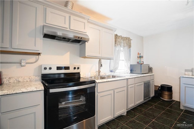 kitchen featuring stainless steel electric stove, dark tile patterned flooring, sink, and white cabinets