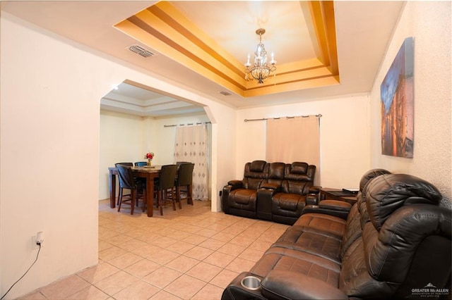 tiled living room featuring a raised ceiling and a chandelier