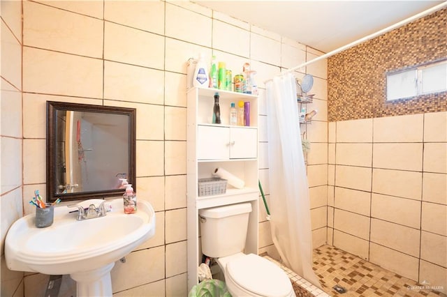 bathroom featuring toilet, sink, tile walls, and walk in shower