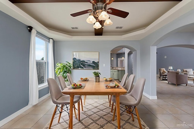 3222 Princess St, Edinburg, TX 78539 - dining space featuring arched walkways, a tray ceiling, a ceiling fan, and light tile patterned floors