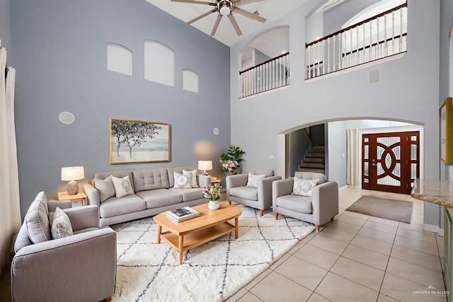 3222 Princess St, Edinburg, TX 78539 - living area featuring a towering ceiling, stairs, a ceiling fan, light tile patterned floors, and arched walkways