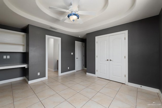 3222 Princess St, Edinburg, TX 78539 - unfurnished bedroom featuring a tray ceiling, light tile patterned floors, a closet, and baseboards