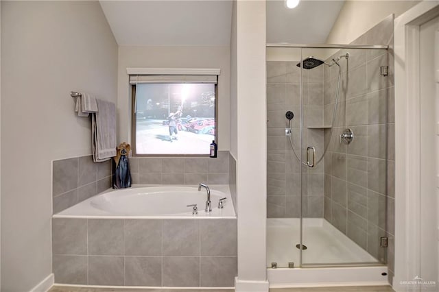 bathroom featuring lofted ceiling and independent shower and bath