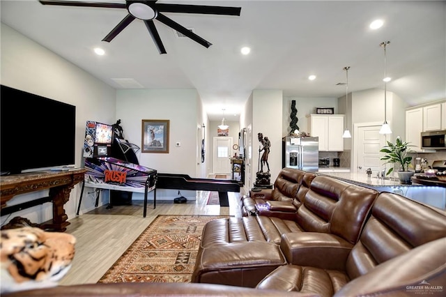 living room featuring ceiling fan and light hardwood / wood-style flooring