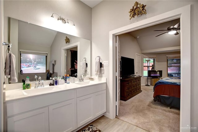 bathroom featuring ceiling fan, vanity, and vaulted ceiling