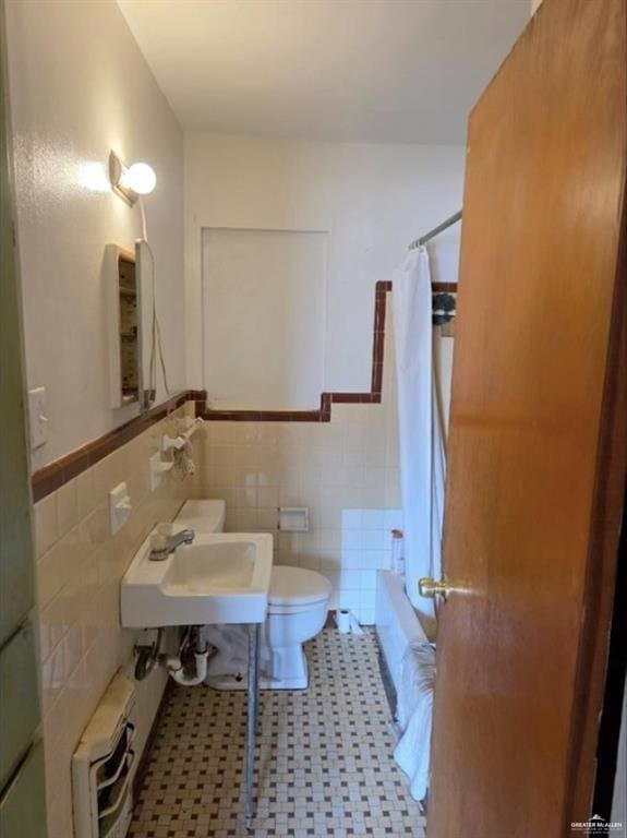 1001 S 5th Ave, Edinburg, TX 78539 - bathroom featuring tile walls, radiator, toilet, shower / bath combo, and wainscoting