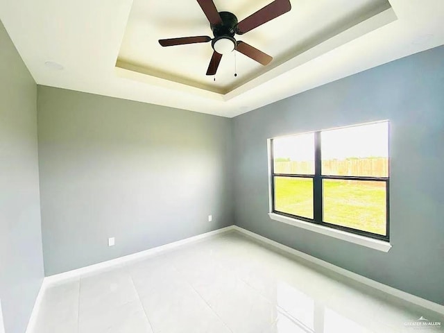 2802 Garman St, Edinburg, TX 78542 - unfurnished room with a tray ceiling, light tile patterned floors, baseboards, and a ceiling fan