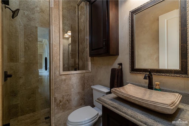 bathroom with toilet, a shower with door, and vanity