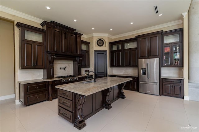 kitchen featuring sink, light tile patterned flooring, a kitchen bar, a kitchen island with sink, and appliances with stainless steel finishes