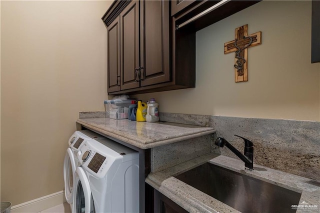 laundry room with sink, washer and clothes dryer, and cabinets