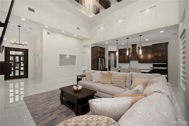 living room with a high ceiling and an inviting chandelier