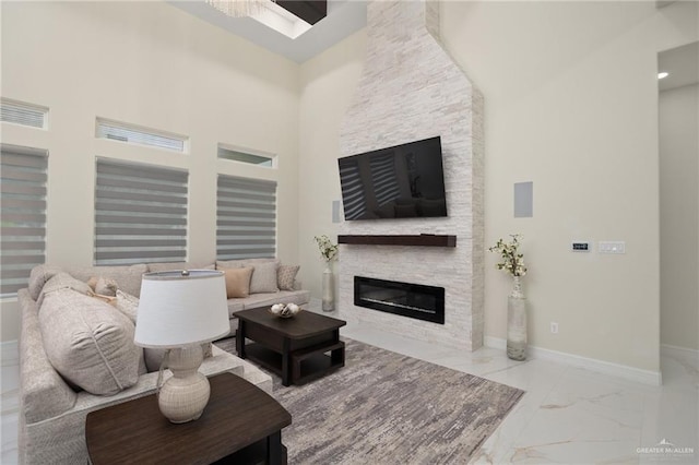 living room featuring a stone fireplace and a towering ceiling