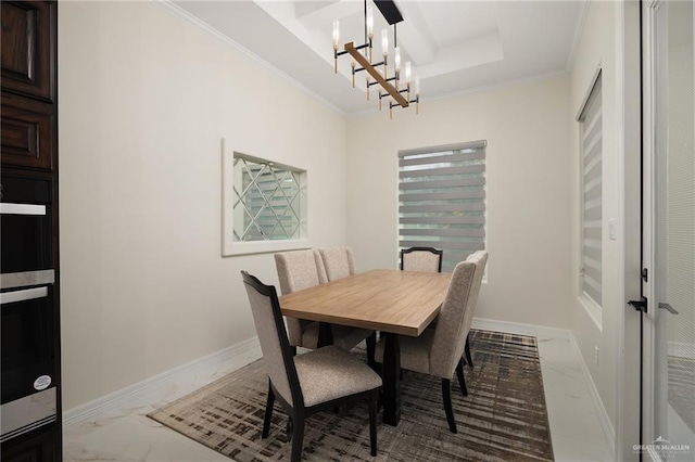 dining room featuring a raised ceiling, a chandelier, and ornamental molding