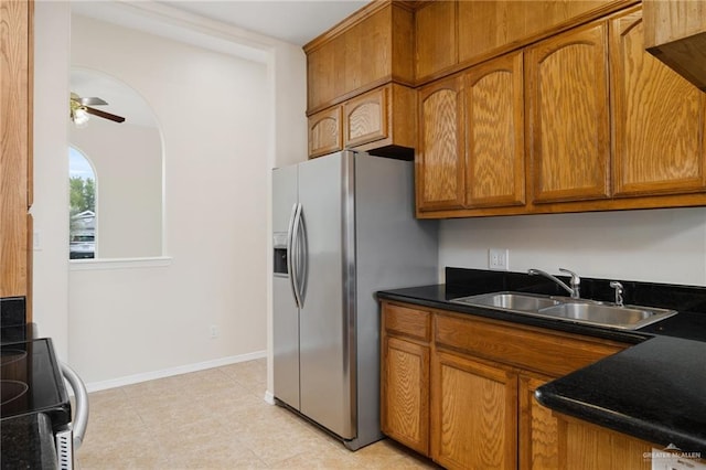 kitchen featuring ceiling fan, stainless steel fridge, range, and sink