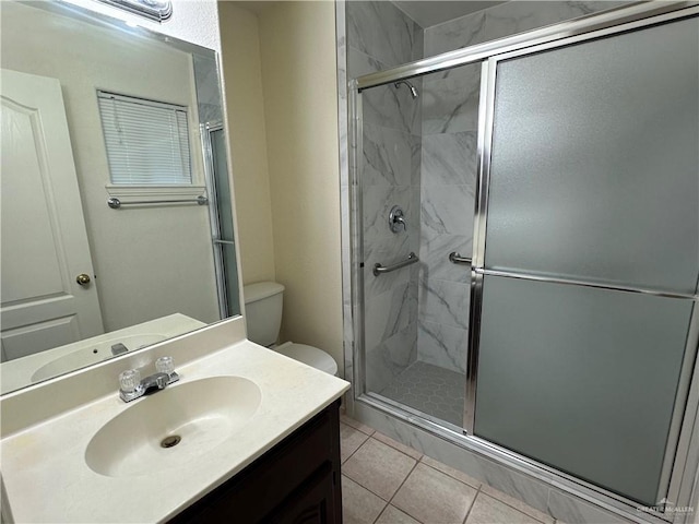 bathroom with toilet, tile patterned floors, a marble finish shower, and vanity