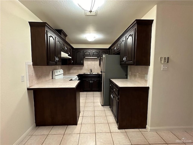 kitchen featuring light countertops, white electric range, under cabinet range hood, and dark brown cabinets