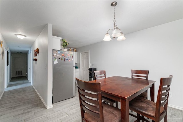 3004 Diaz Ave, Mcallen, TX 78503 - dining space with a chandelier, light wood-style flooring, and baseboards