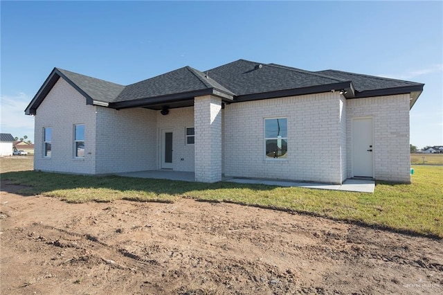 rear view of property with a yard and a patio