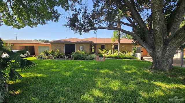 409 Redwood Ave, Mcallen, TX 78501 - view of front of home featuring a front yard, brick siding, and an attached garage