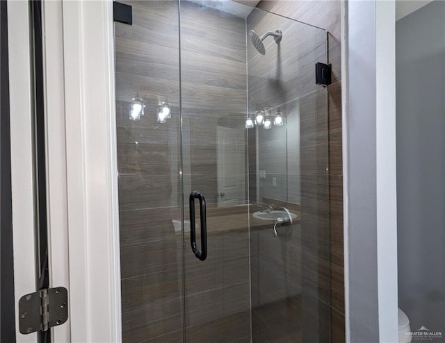 bathroom featuring an enclosed shower and toilet