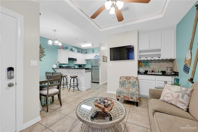 107 E Pike St Unit 2, South Padre Island, TX 78597 - living room featuring ceiling fan, light tile patterned floors, a tray ceiling, and baseboards