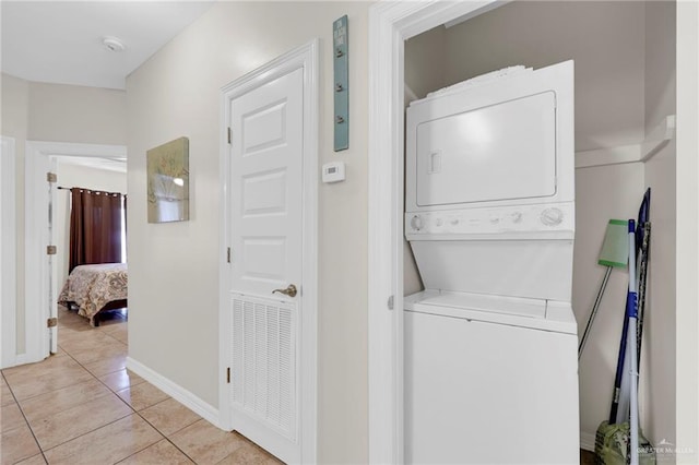 107 E Pike St Unit 2, South Padre Island, TX 78597 - laundry area featuring stacked washer / dryer, light tile patterned floors, and baseboards