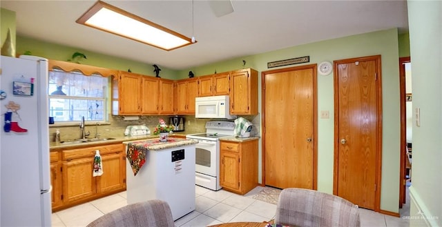 kitchen with decorative backsplash, white appliances, sink, a center island, and light tile patterned flooring