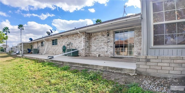 back of house with a patio area, central air condition unit, and a yard