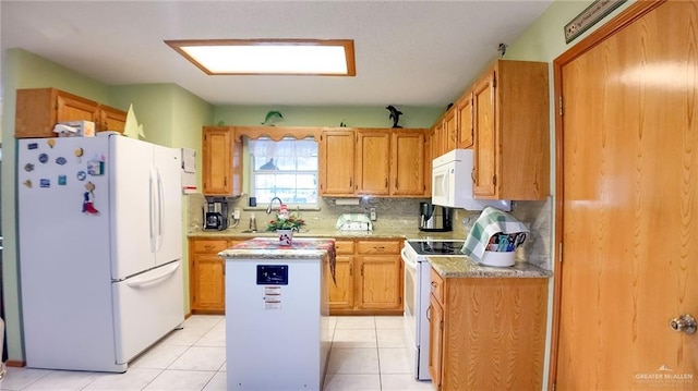 kitchen with a kitchen island, white appliances, sink, and light tile patterned floors