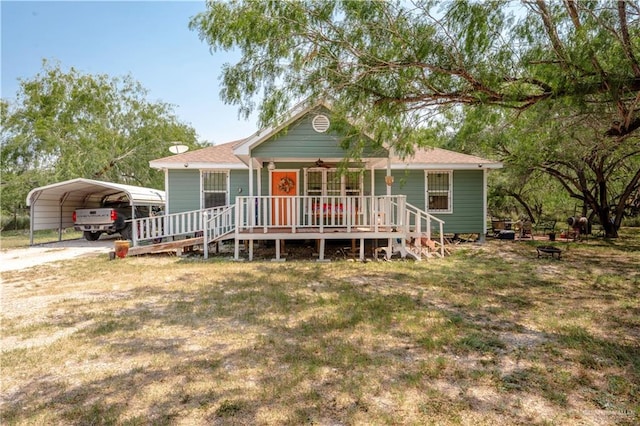 view of front of home featuring a carport, covered porch, and a front lawn