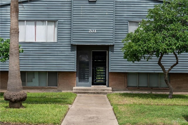 view of exterior entry featuring a yard